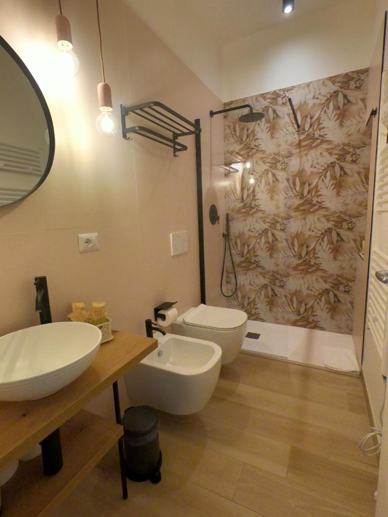 une salle de bain avec un lavabo, des toilettes et un miroir dans l'établissement Malia Holiday Villa, à Conversano