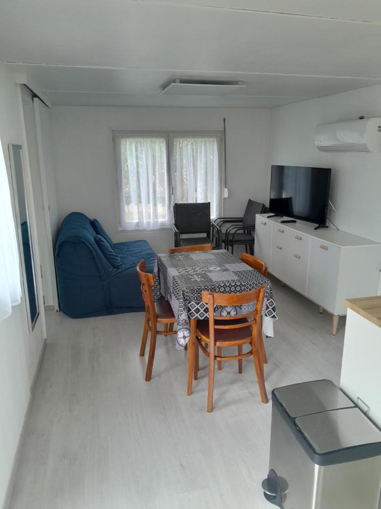 un salon avec une table, des chaises et un canapé dans l'établissement Un petit havre de paix, à La Rouviere