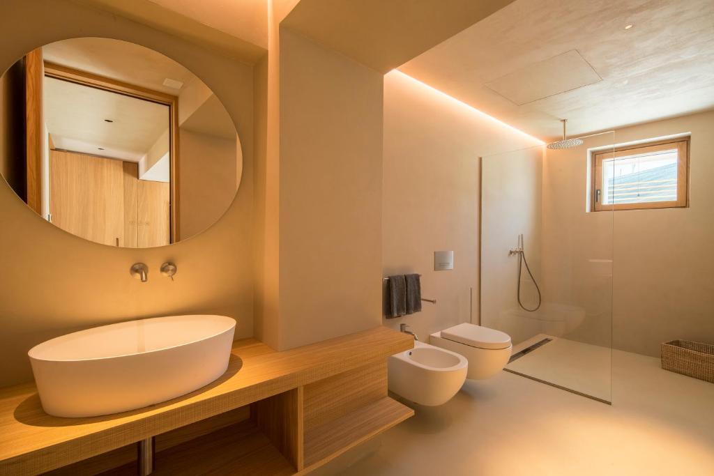 une salle de bain avec un lavabo, des toilettes et un miroir dans l'établissement Calitro Mare, à Torre Ovo