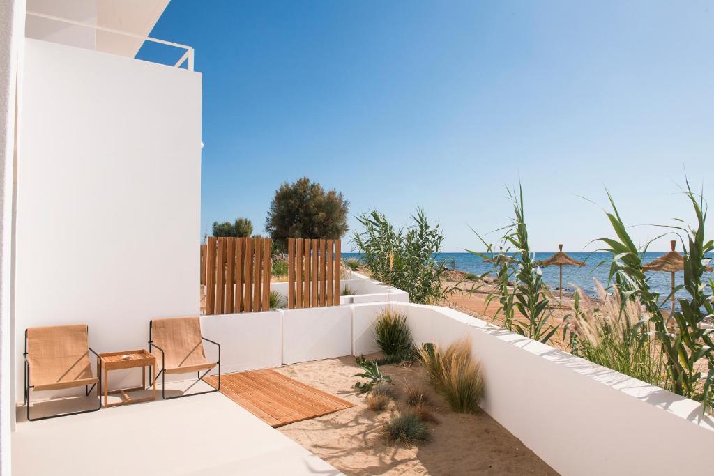 - deux chaises assises sur une terrasse donnant sur l'océan dans l'établissement Calitro Mare, à Torre Ovo