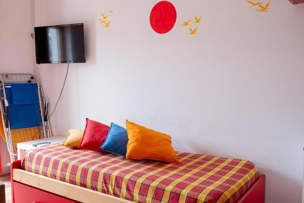 Cette chambre comprend un lit avec des oreillers colorés. dans l'établissement Residence La Giungla, à Falerna 63 autres photos