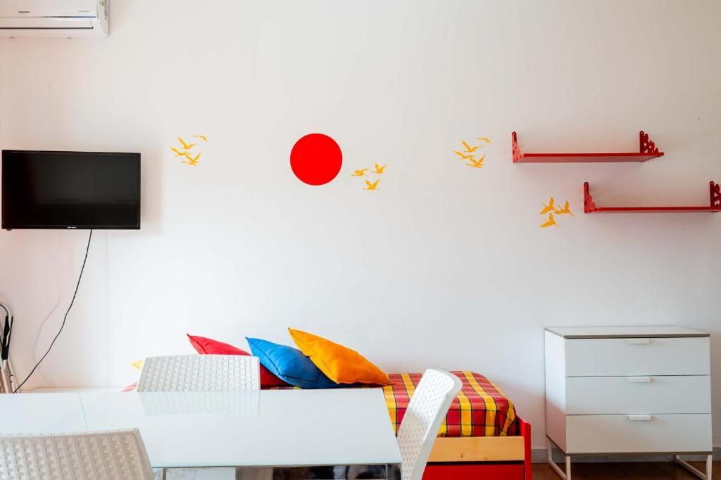 un salon avec une table et une télévision au mur dans l'établissement Residence La Giungla, à Falerna