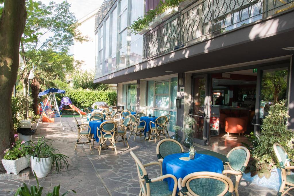 un groupe de tables et de chaises à l'extérieur d'un bâtiment dans l'établissement Hotel Mirage, à Bellaria-Igea Marina