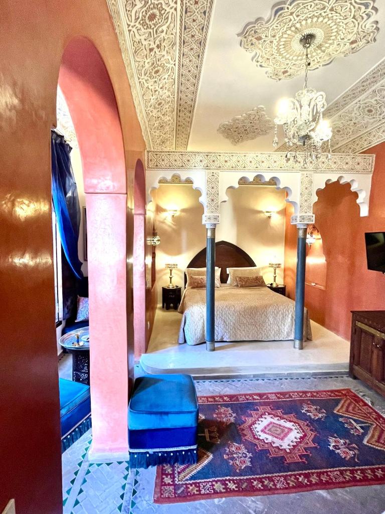 une chambre avec un lit et un lustre dans l'établissement Riad Fatinat Marrakech, à Marrakech