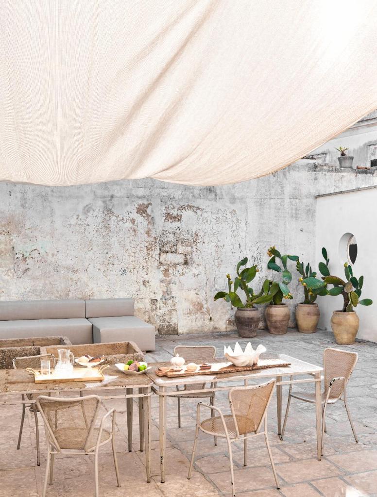 Cette chambre est dotée de tables, de chaises et d'un mur blanc. dans l'établissement Palazzo Giustiniani L'Ambasciatore, à Sogliano Cavour