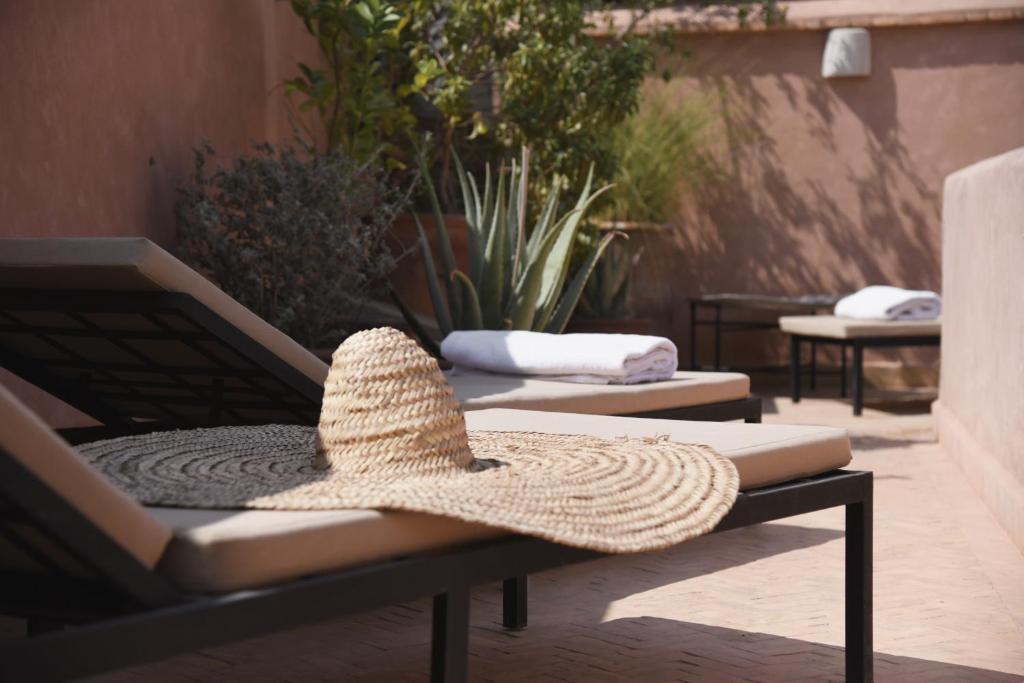 un chapeau de paille assise sur un banc dans l'établissement Riad Muarid, à Marrakech