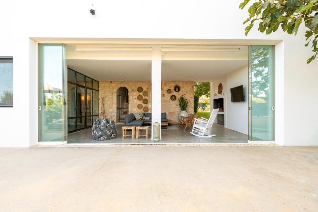 une extension en verre d'une maison avec un salon dans l'établissement Torlevigne Relax & Pool, à Polignano a Mare