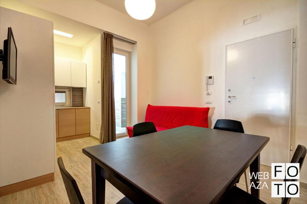 - une salle à manger avec une table et un canapé rouge dans l'établissement La Perla del Mare di Polignano Apartments, à Polignano a Mare