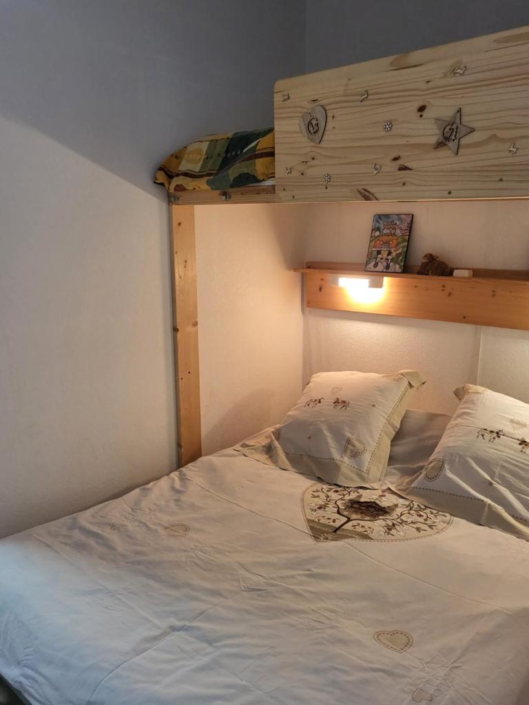 une chambre avec un lit blanc avec deux oreillers dans l'établissement Superdevoluy Appart Rez de Neige, à Saint-Étienne-en-Dévoluy