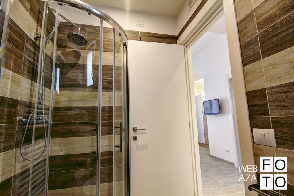 une douche avec une porte vitrée dans une pièce dans l'établissement La Perla del Mare di Polignano Apartments, à Polignano a Mare 28 autres photos