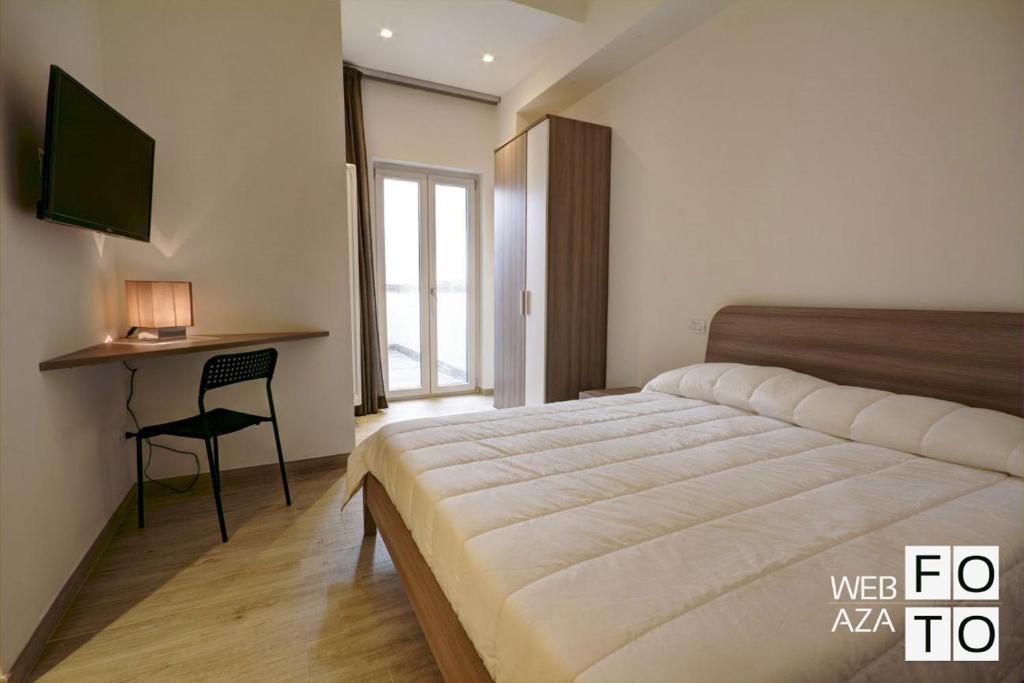 une chambre avec un lit, un bureau et une fenêtre dans l'établissement La Perla del Mare di Polignano Apartments, à Polignano a Mare