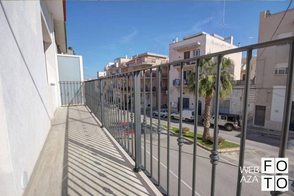 un balcon avec vue sur une rue de la ville dans l'établissement La Perla del Mare di Polignano Apartments, à Polignano a Mare