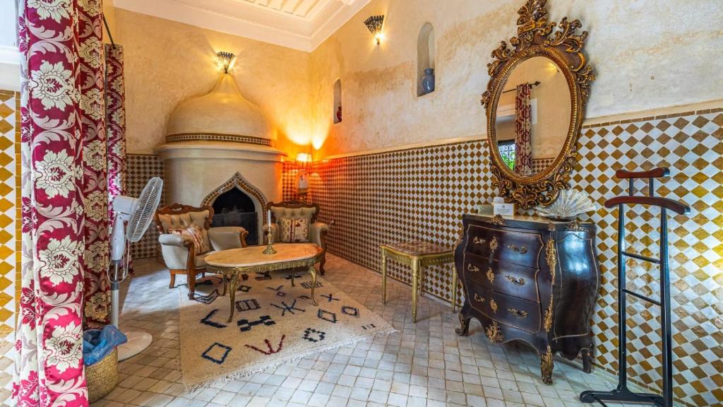 - un salon avec un miroir, une table et une cheminée dans l'établissement Riad ABBASSIA Marrakech Premiere, à Marrakech