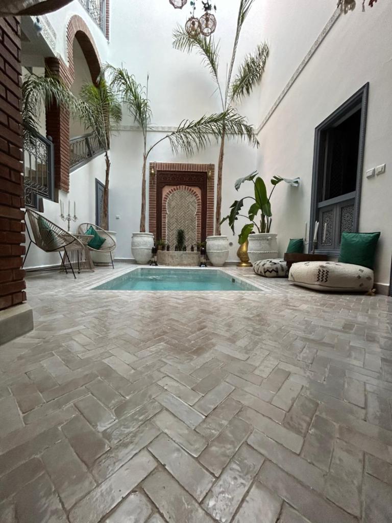 d'une terrasse avec une piscine et une cheminée. dans l'établissement RIAD TIFAWT, à Marrakech