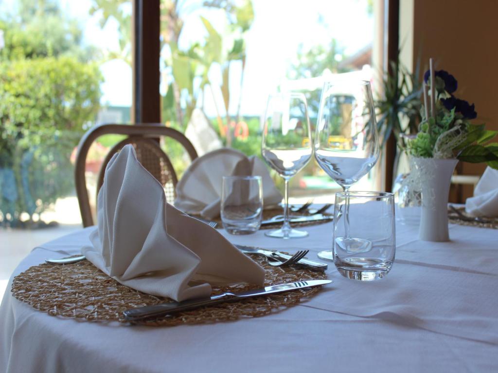 - une table avec un chiffon de table blanc et des verres à vin dans l'établissement Blu Tropical Resort, à Zambrone