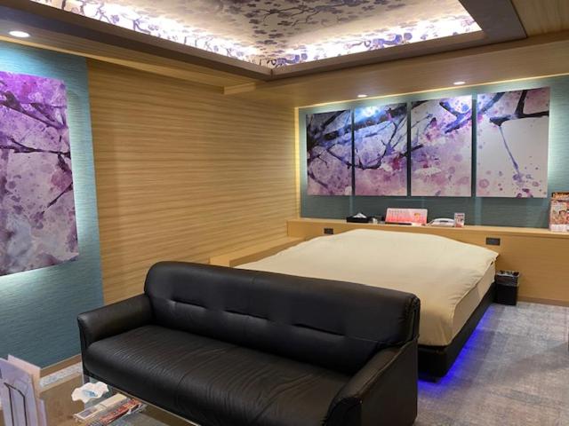 une chambre avec un lit et un canapé dans l'établissement HOTEL Hana - Adult Only, à Matsumoto