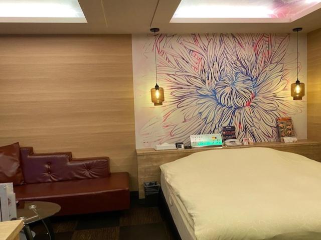 une chambre avec un lit et un tableau au mur dans l'établissement HOTEL Hana - Adult Only, à Matsumoto