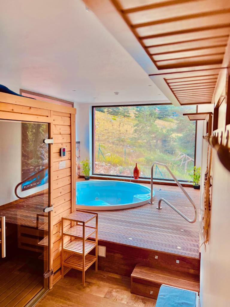 Cette chambre dispose d'une grande baignoire et d'une grande fenêtre. dans l'établissement Auberge Alpina, à Gréolières