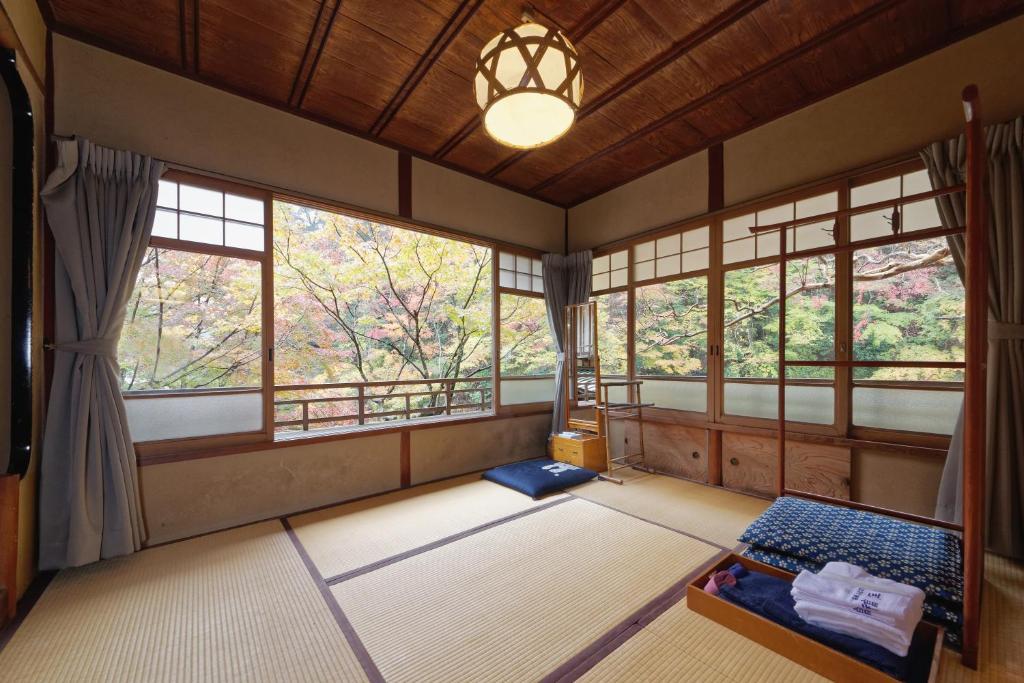 une salle de méditation avec des fenêtres et un lustre dans l'établissement Fukuzumiro, à Hakone