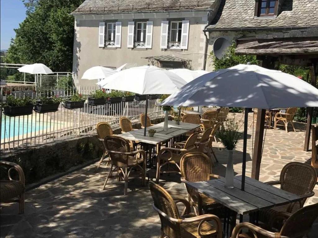 un patio extérieur avec des tables, des chaises et des parasols dans l'établissement Camping 3 étoiles - Piscine - eehgge, à Banes