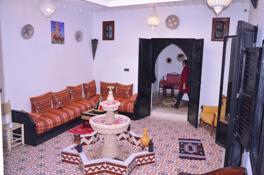 un salon avec un canapé et une table dans l'établissement Riad Benrahal, à Marrakech