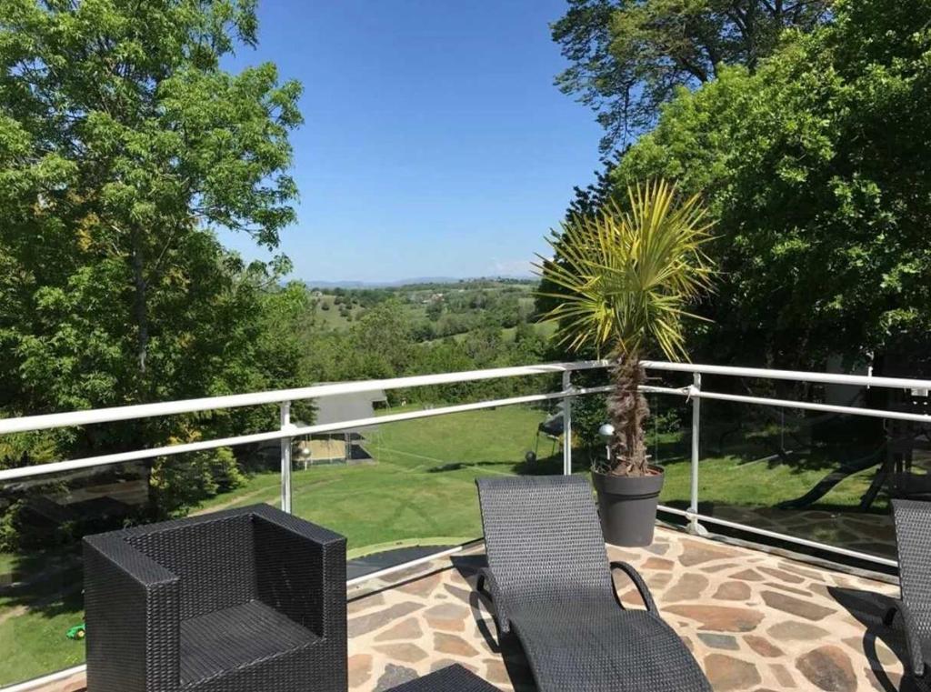 d'une terrasse avec 2 chaises et d'une télévision sur un balcon. dans l'établissement Camping 3 étoiles - Piscine - eehgge, à Banes 1 autre photo
