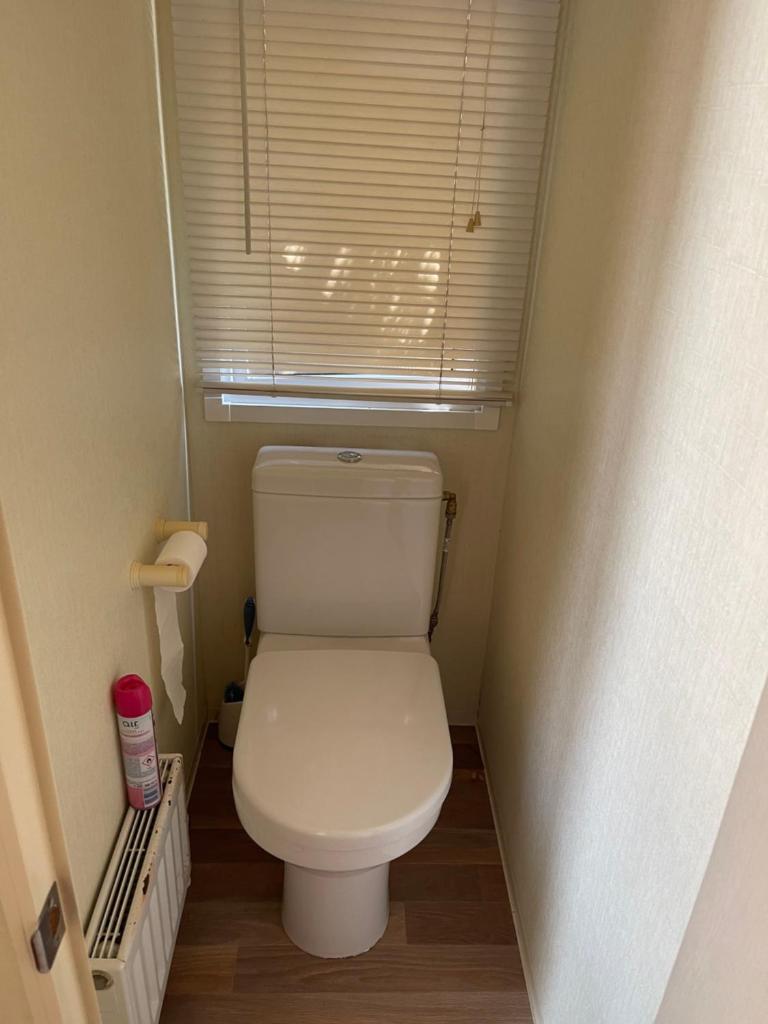 Elle comprend une petite salle de bains pourvue de toilettes et d'une fenêtre. dans l'établissement Chez Flo Charmant mobile-home H89, à Gassin