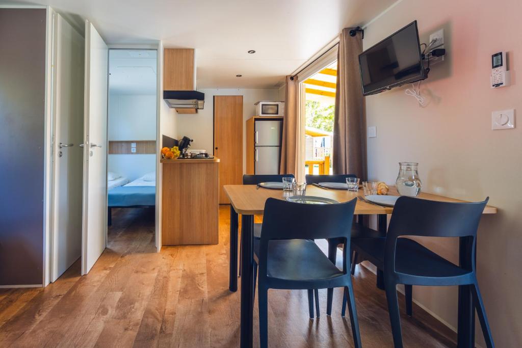 une cuisine et une salle à manger avec une table et des chaises dans l'établissement L'Oasis des Dombes, à Ambérieux-en-Dombes