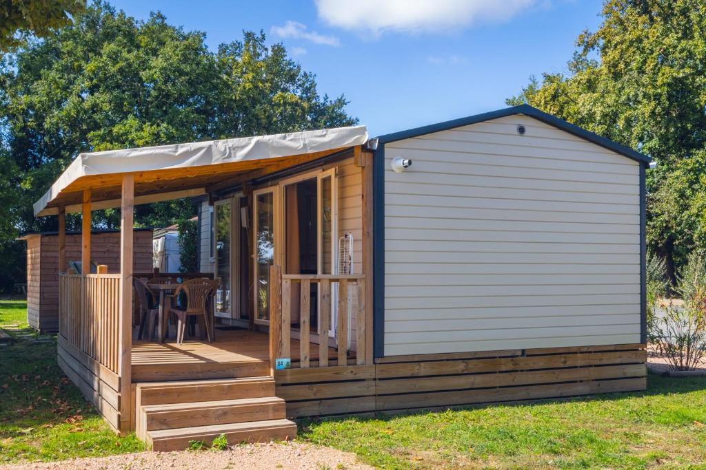 un petit hangar avec une terrasse couverte et une terrasse dans l'établissement L'Oasis des Dombes, à Ambérieux-en-Dombes
