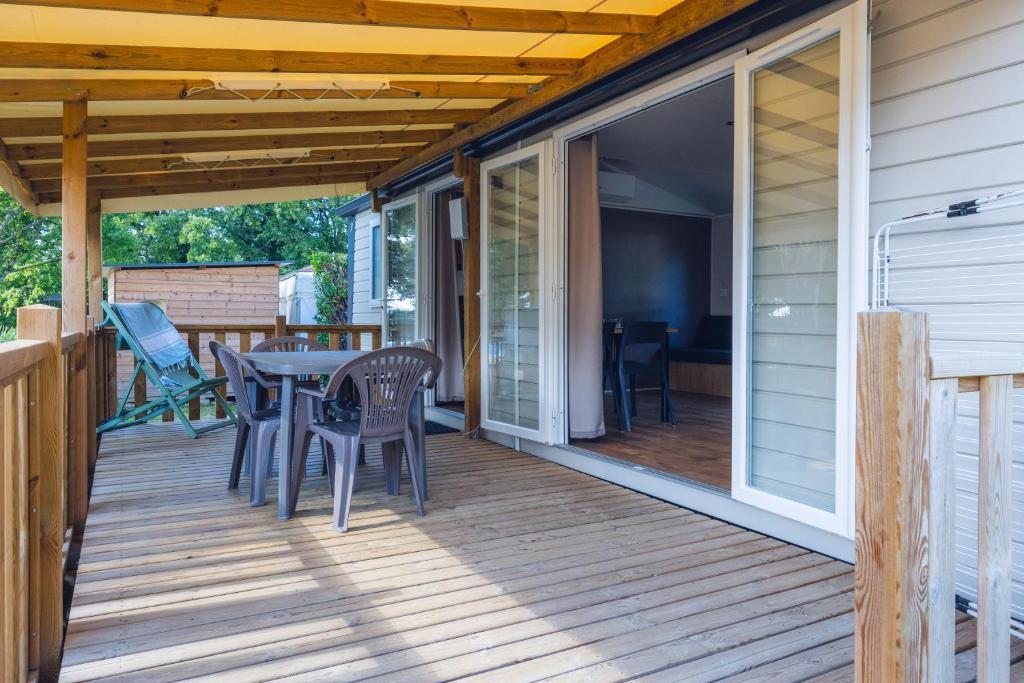 un patio avec une table et des chaises sur une terrasse dans l'établissement L'Oasis des Dombes, à Ambérieux-en-Dombes