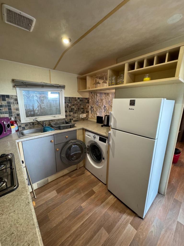 une cuisine avec un réfrigérateur et une machine à laver dans l'établissement Chez Flo Charmant mobile-home H89, à Gassin 5 autres photos