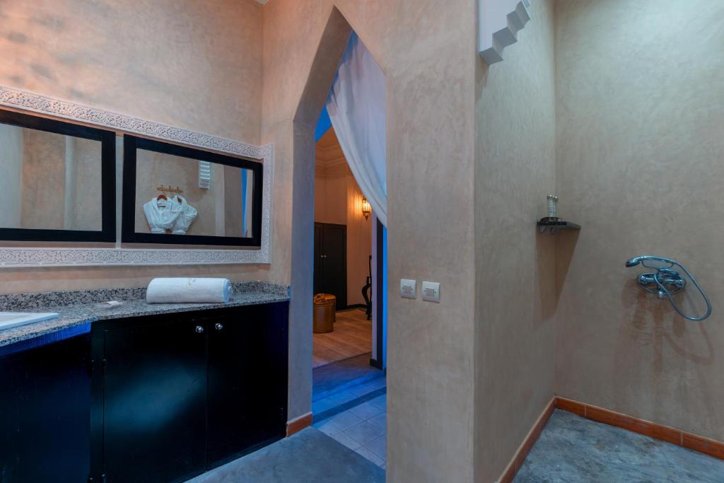 La salle de bains est pourvue d'un lavabo et d'une douche à l'italienne. dans l'établissement Riad L'ECOLE, à Marrakech
