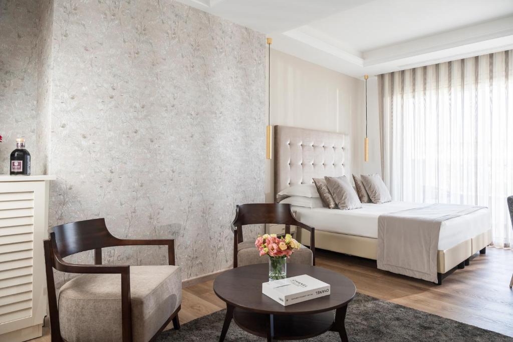 une chambre avec un lit, une table et des chaises dans l'établissement Grand Hotel Gallia, à Milano Marittima