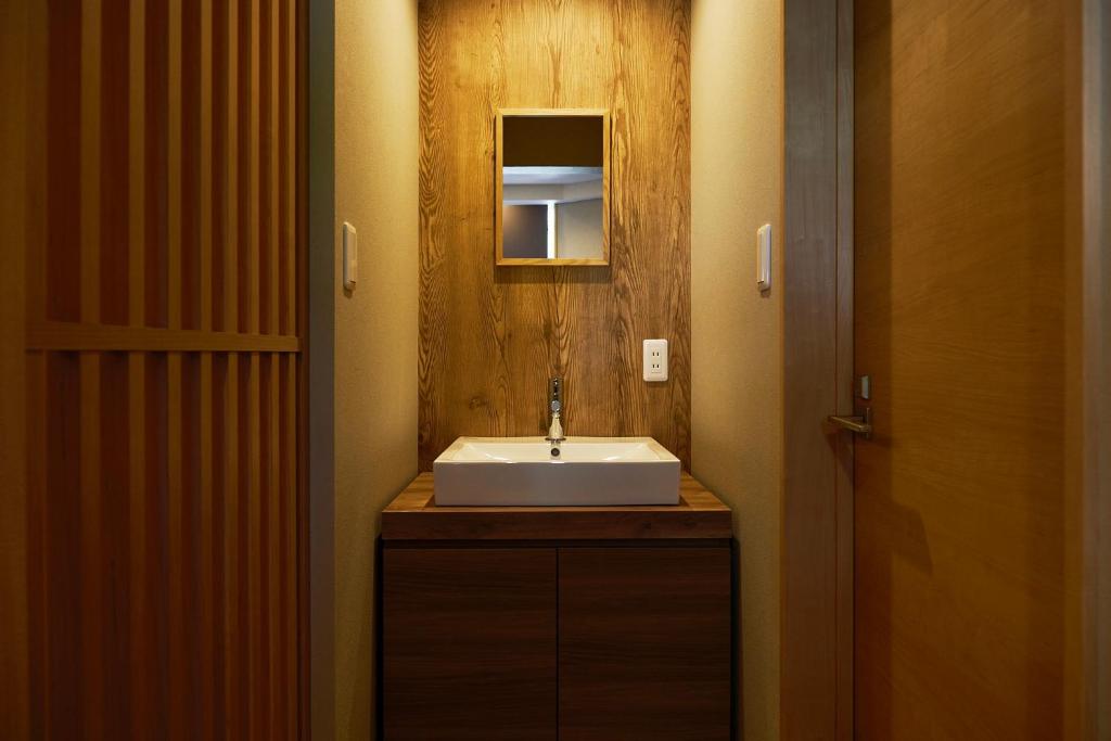 une salle de bain avec un lavabo et un miroir dans l'établissement メイプルハイム, à Iiyama