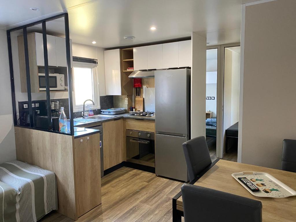 - une cuisine avec un réfrigérateur et une table dans la chambre dans l'établissement Chez Isa, à Saint-Julien-en-Born