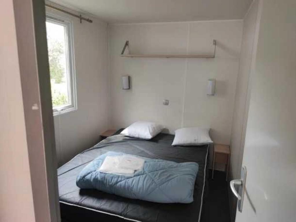 une petite chambre avec un lit et une fenêtre dans l'établissement Camping 4 étoiles - Parc aquatique - eehhd0, à Saint-Cyprien