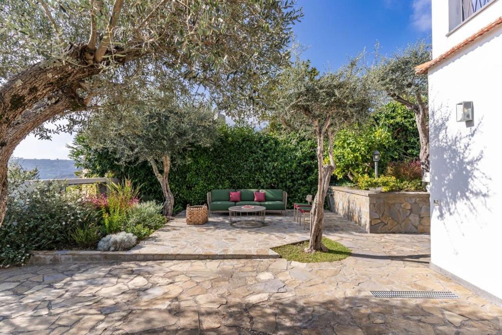 une terrasse avec un canapé, une table et des arbres dans l'établissement Villa Chez Piè Panoramic Views Pool and Guest Services, à SantʼAgata sui Due Golfi