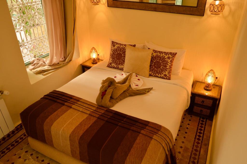 une chambre avec un lit avec un ours en peluche dessus dans l'établissement Riad Jalina, à Marrakech