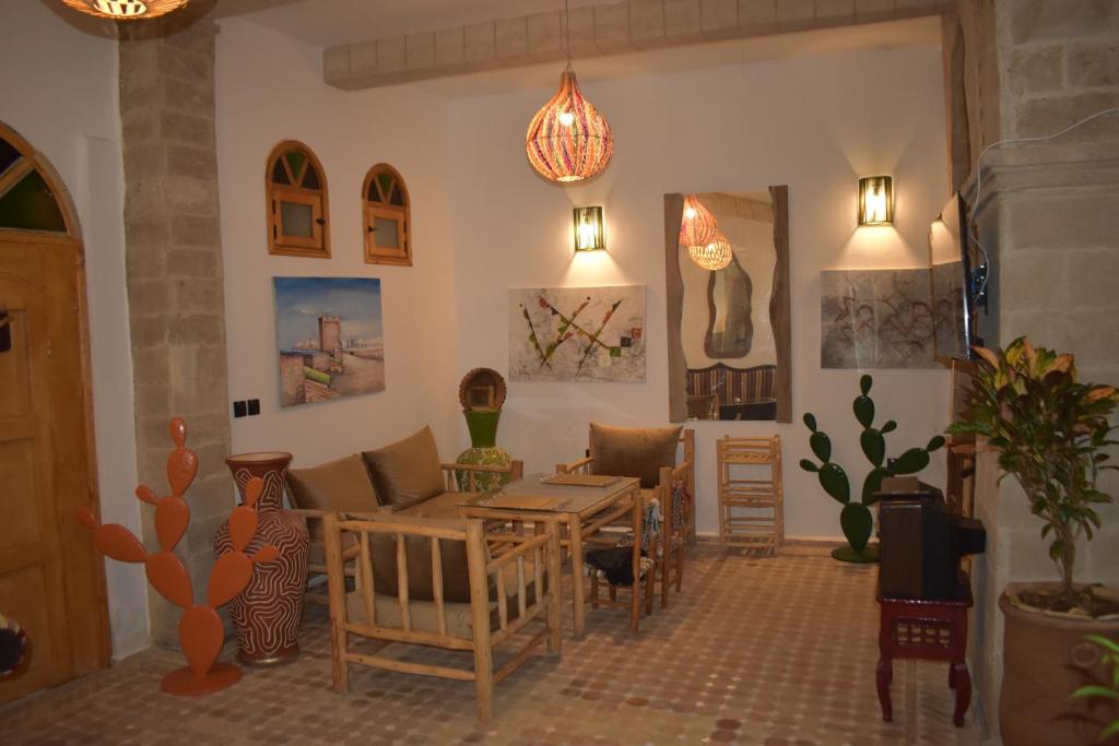 un salon avec une table et des chaises dans l'établissement Riad Mogantique-Essaouira, à Essaouira