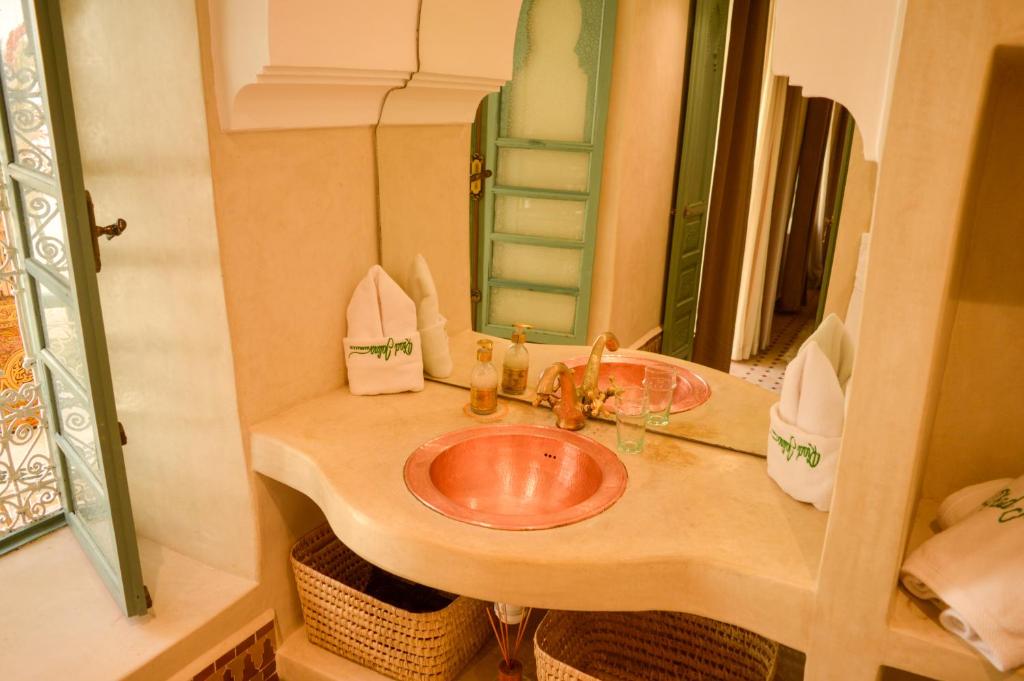 une salle de bain avec un lavabo et un miroir dans l'établissement Riad Jalina, à Marrakech 37 autres photos