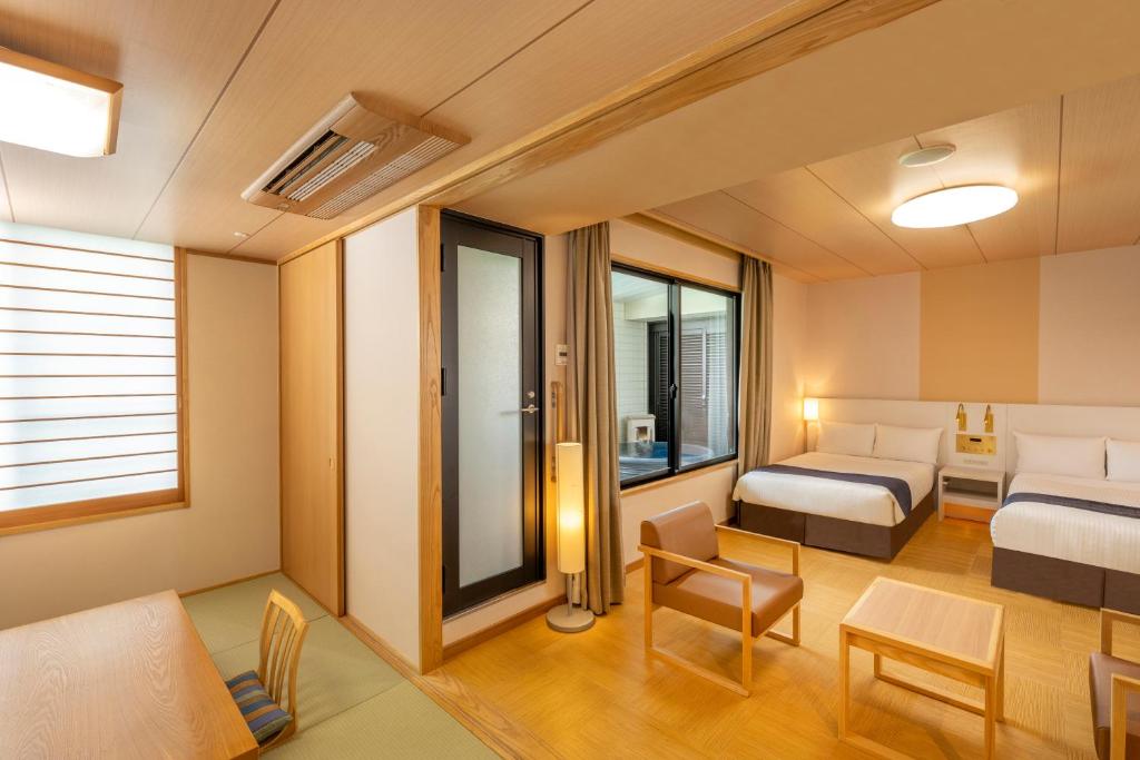 une chambre d'hôtel avec un lit et une table dans l'établissement KAMENOI HOTEL Yanagawa, à Yanagawa