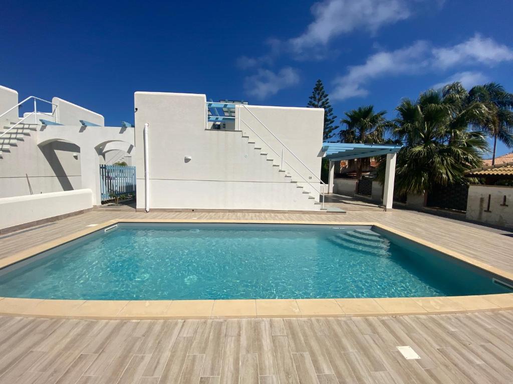 une piscine devant une maison dans l'établissement Villa Portofino, à Campofelice di Roccella