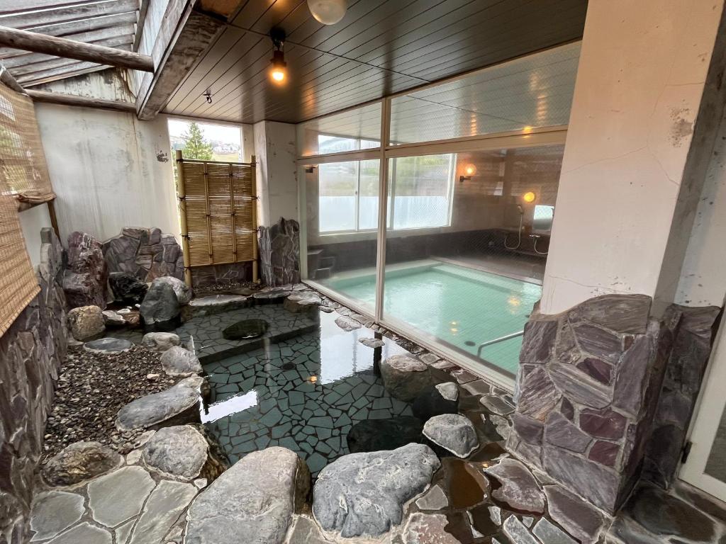 - une piscine dans une maison avec une grande fenêtre dans l'établissement Hotel Yuzawa Yuzawa Denkiya, à Yuzawa
