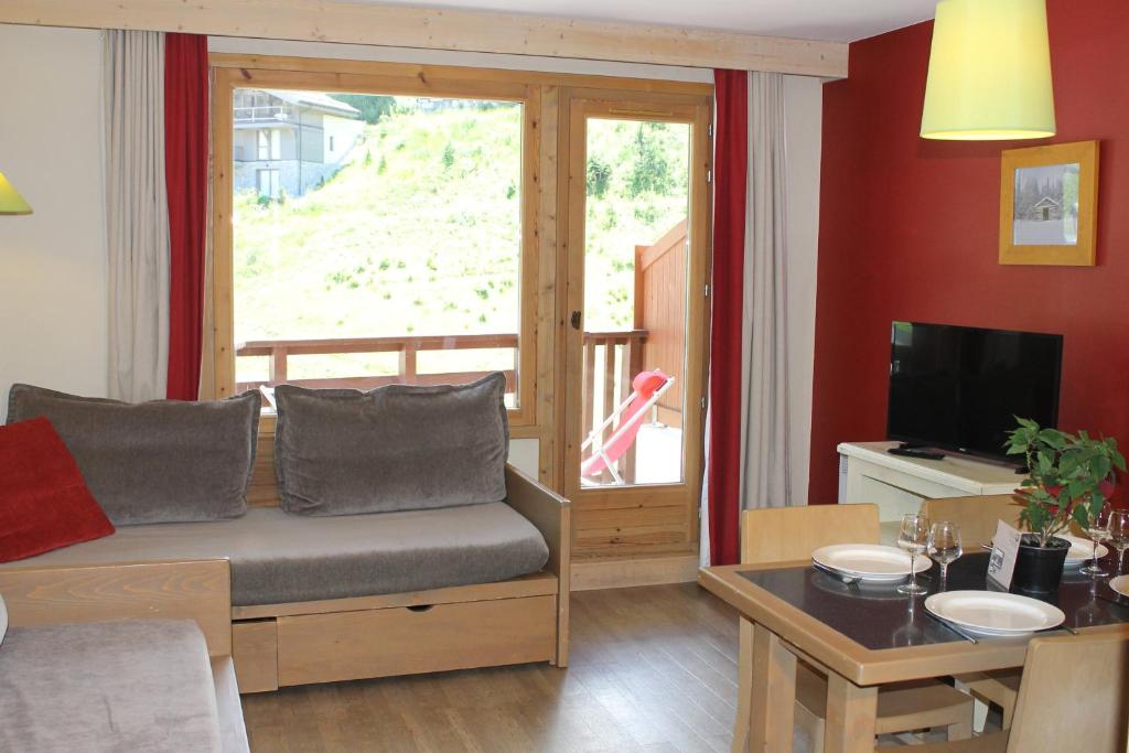 un salon avec un canapé et une grande fenêtre dans l'établissement Résidence Christiana 307 Clés Blanches Courchevel, à Courchevel