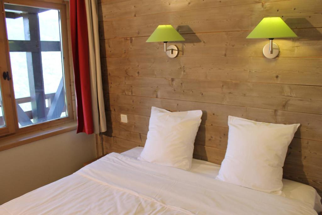 une chambre avec un lit avec deux lampes et deux oreillers dans l'établissement Résidence Christiana 408 Clés Blanches Courchevel, à Courchevel