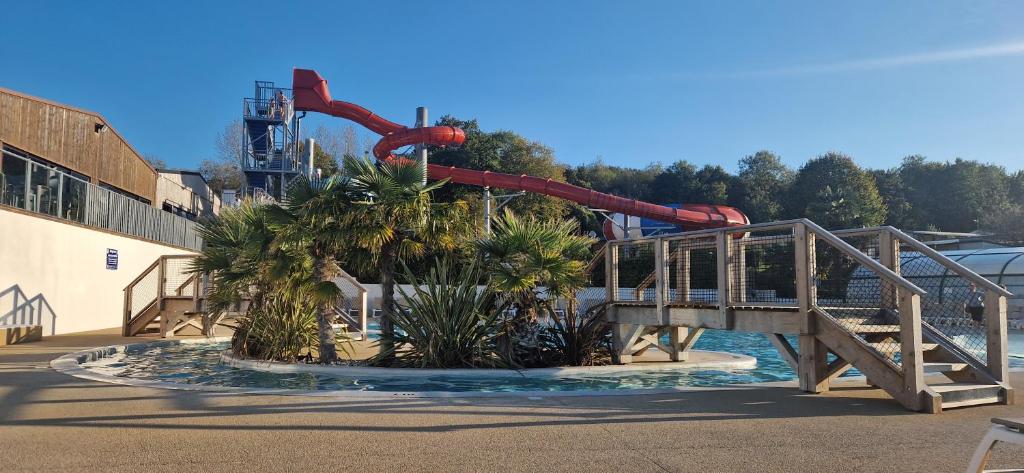 - un parc aquatique avec une piste de rouleaux rouges dans l'établissement Camping 5 étoiles piscines chauffées club enfants mobilhome premium 6pers, à Houlgate