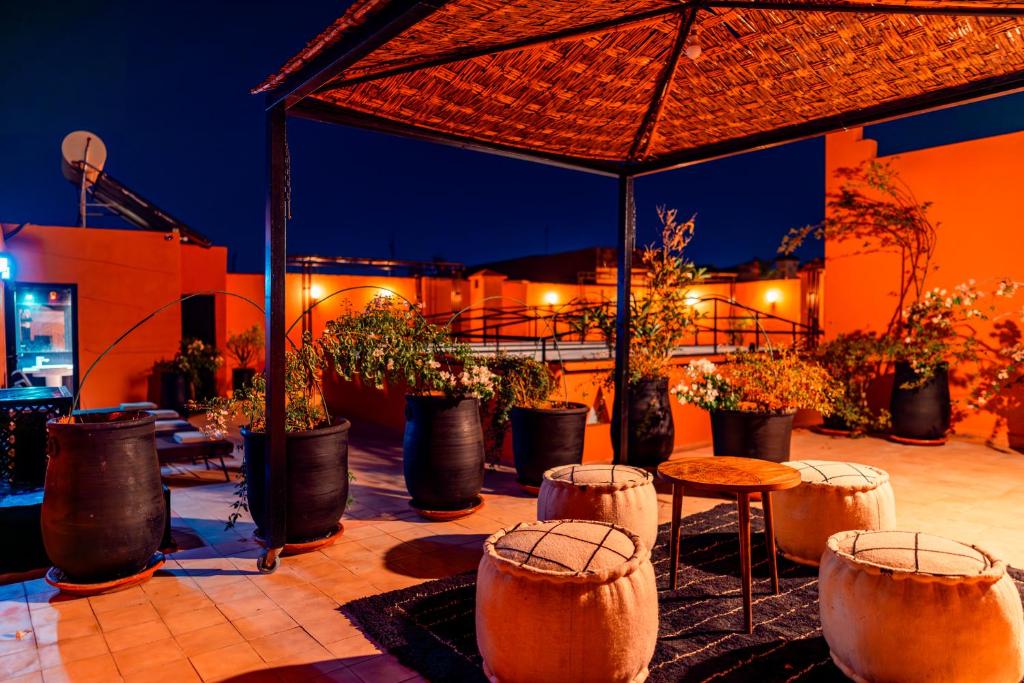 un patio avec un bouquet de plantes en pot et un parasol dans l'établissement Riad L'ECOLE, à Marrakech