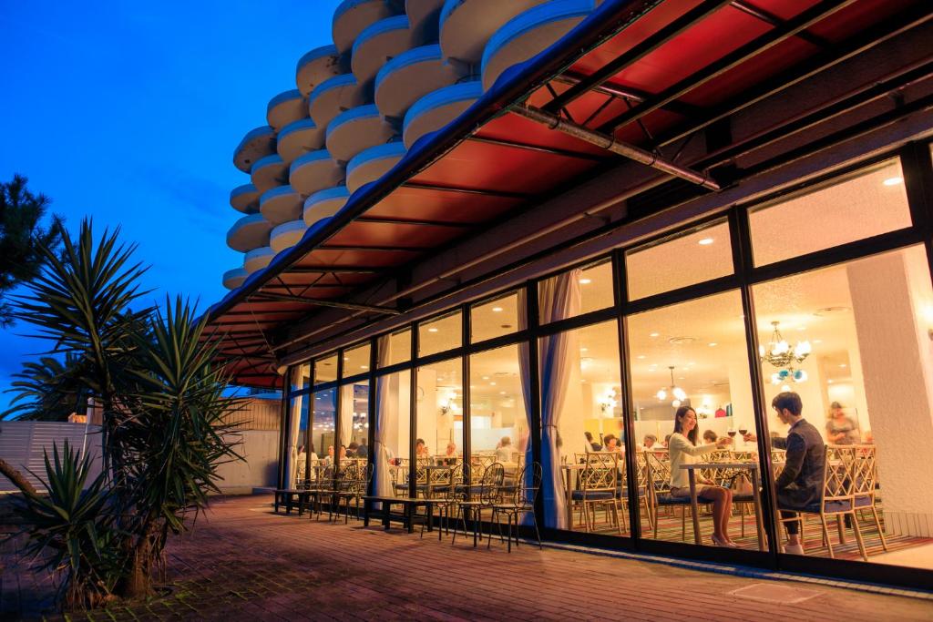 un groupe de personnes assises à des tables dans un restaurant dans l'établissement Hotel Green Plaza Hamanako, à Hamamatsu