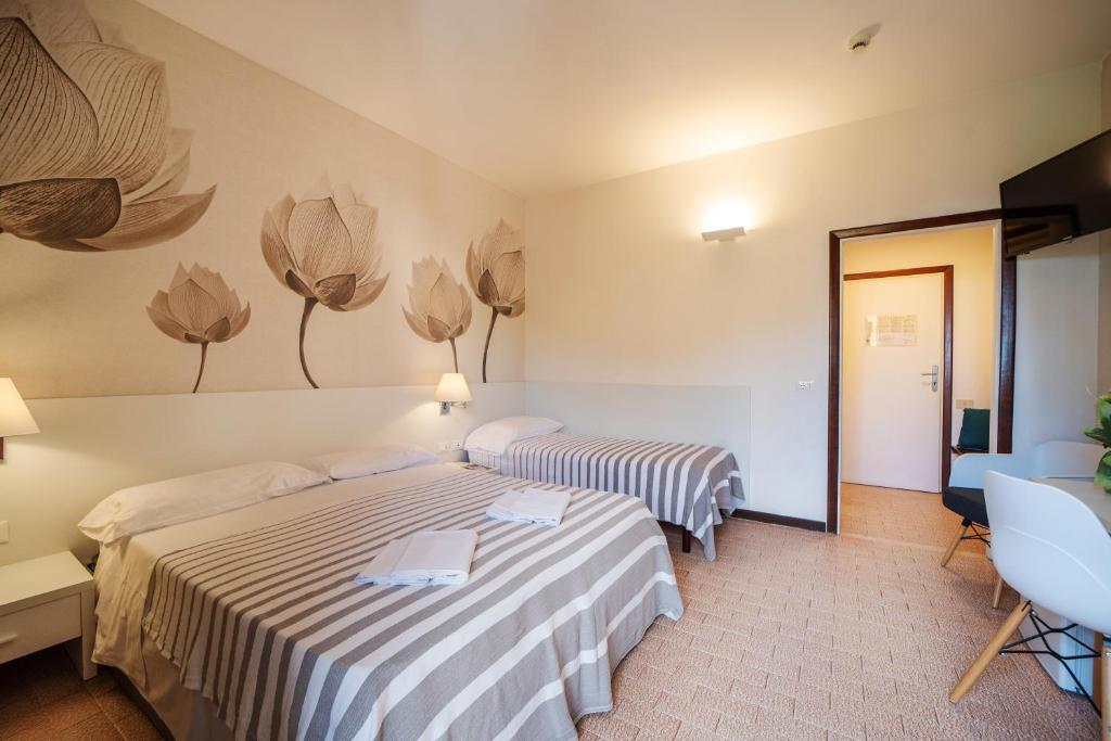 une chambre d'hôtel avec deux lits et un miroir dans l'établissement Frank's Hotel, à Capoliveri