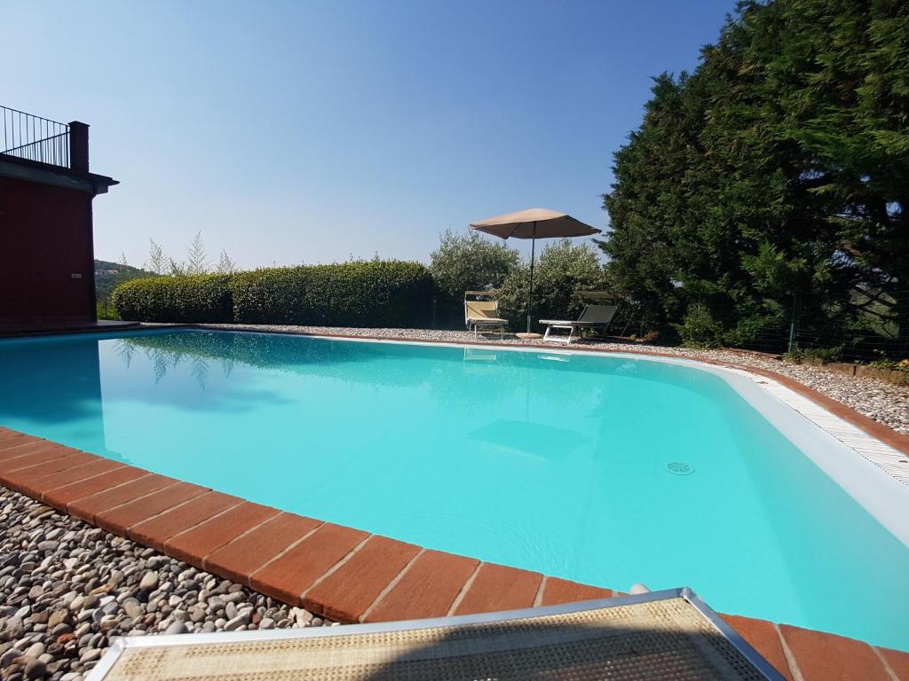 une grande piscine bleue dans une cour dans l'établissement Heated pool - Arte e Terme immerse nella natura, à Massa e Cozzile